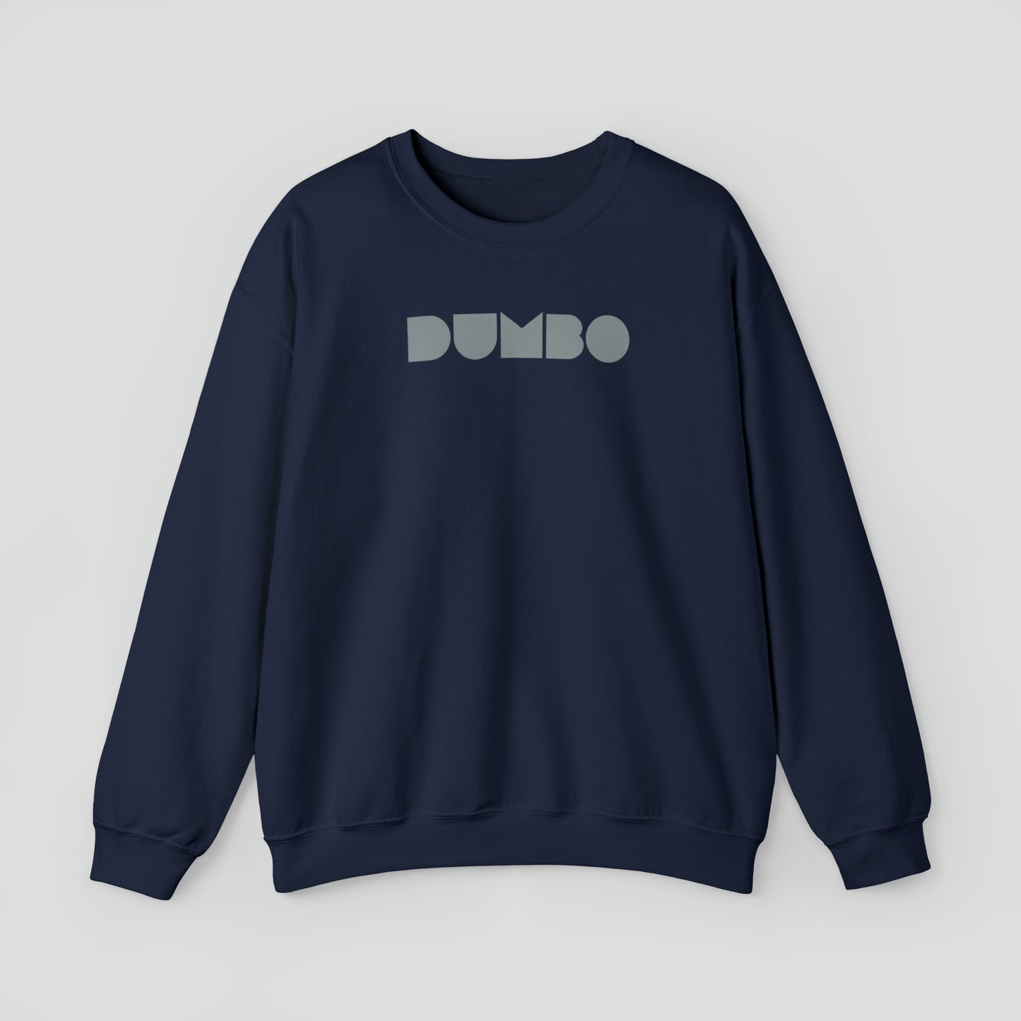 Navy colored sweatshirt with the word Dumbo in gray block letters across the chest, against a gray background.