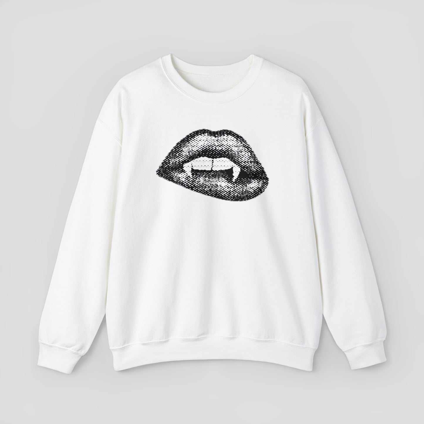 White sweatshirt with open mouth and lips exposing two teeth and two vampire fangs against light gray background.