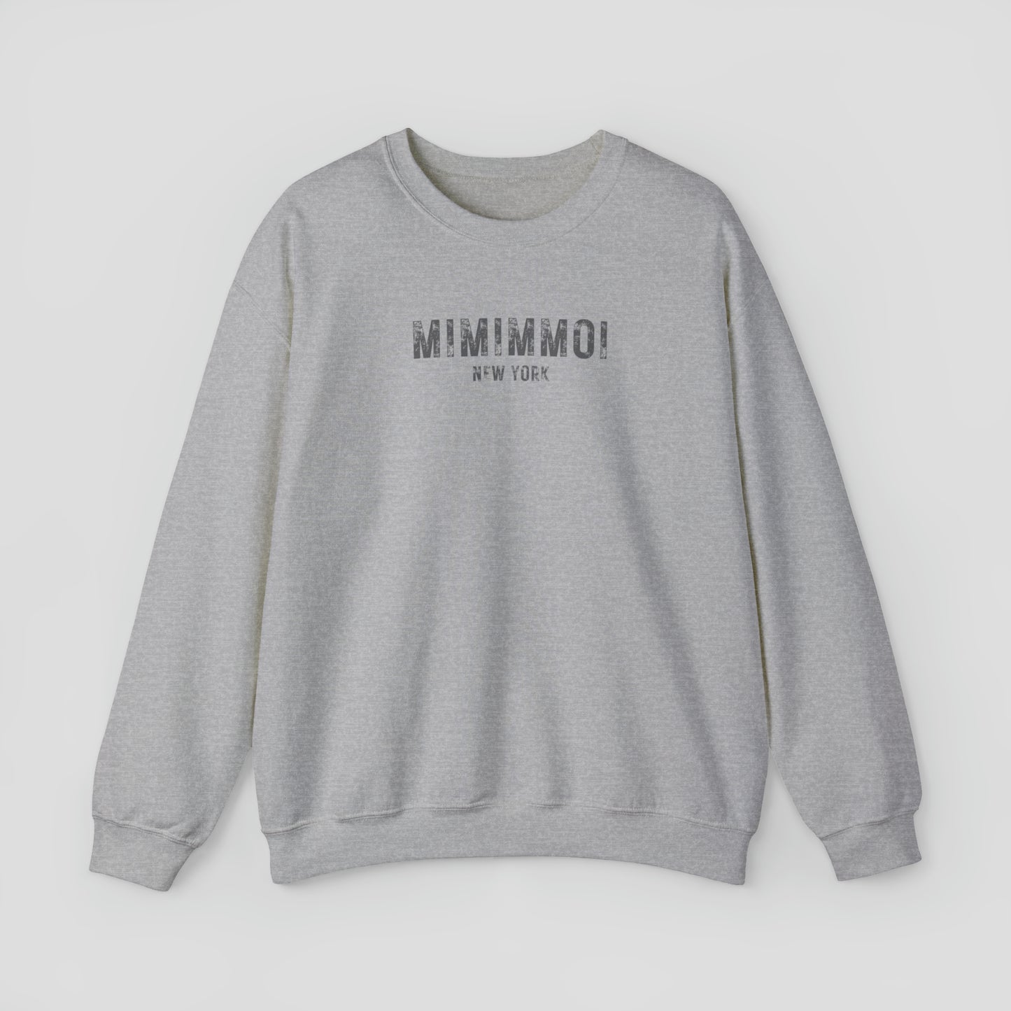 Dark gray sweatshirt with the words Mimimmoi New York in distressed gray block letters across the chest, against a gray background.