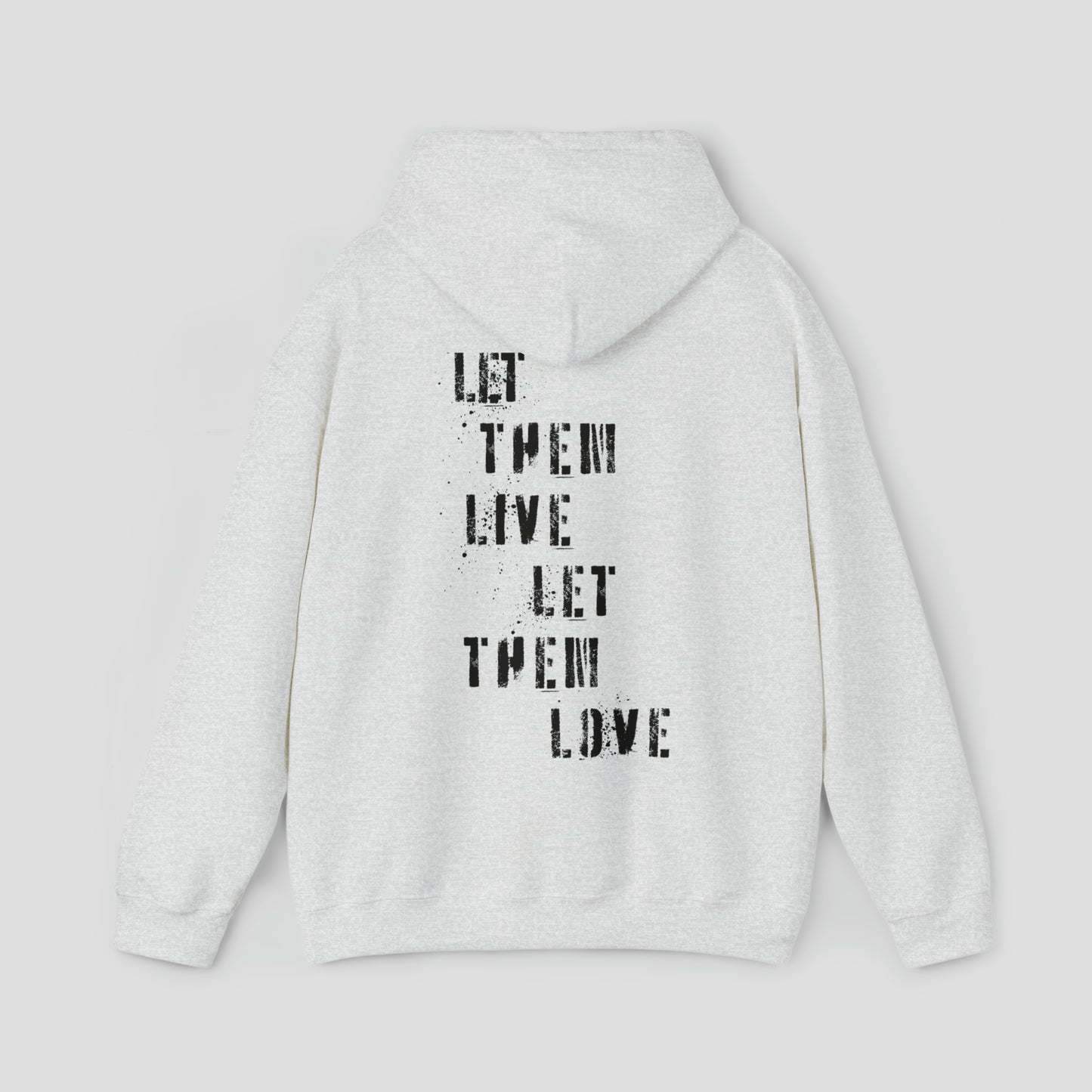 Back view of ash colored hooded sweatshirt with hood down with the words Let Them Live Let Them Love in black spray-paint stenciled font in center, against a gray background.