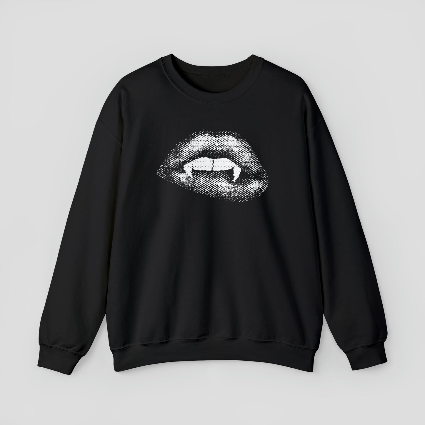 Black sweatshirt with open mouth and lips exposing two teeth and two vampire fangs against light gray background.