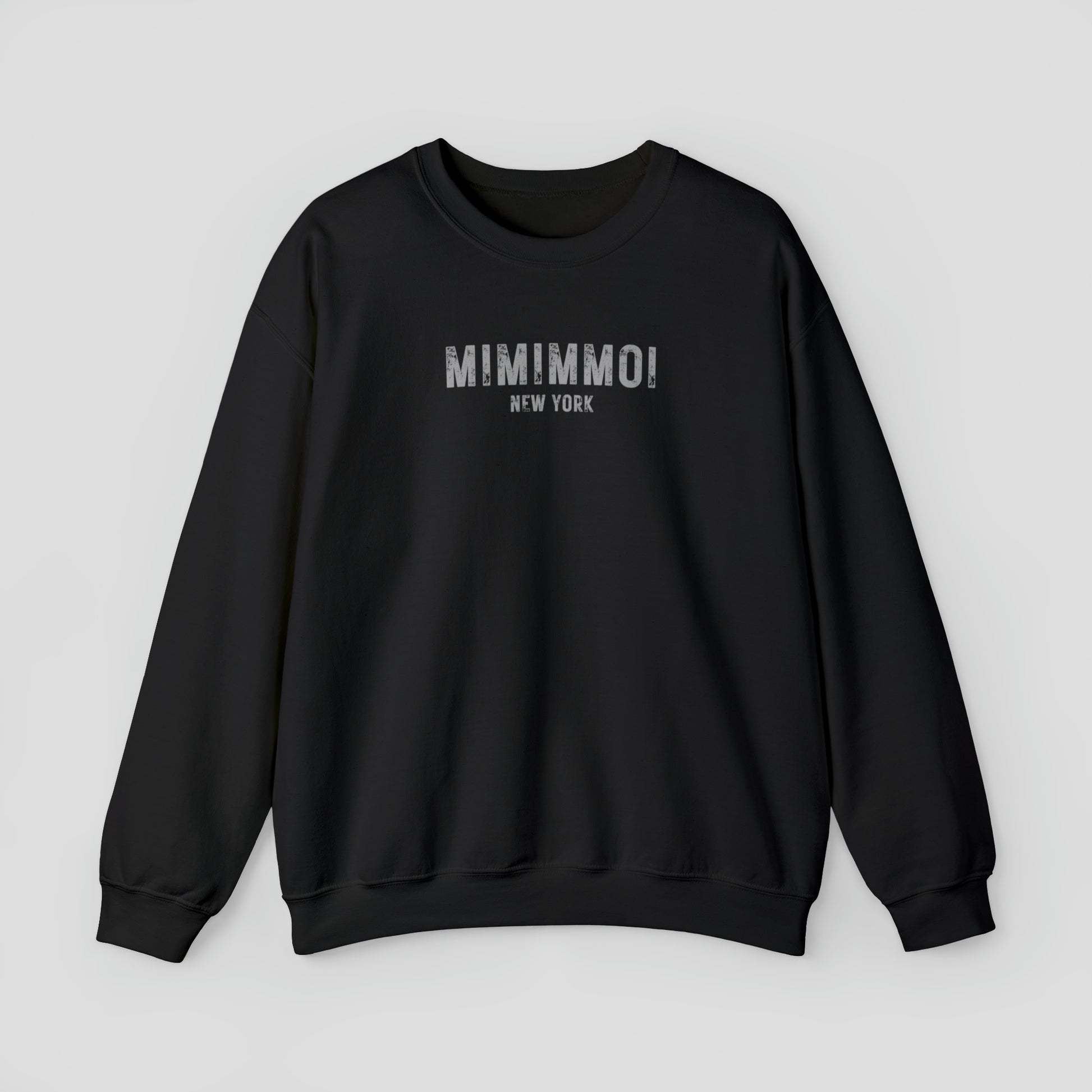 Navy colored sweatshirt with the words Mimimmoi New York in distressed gray block letters across the chest, against a gray background.