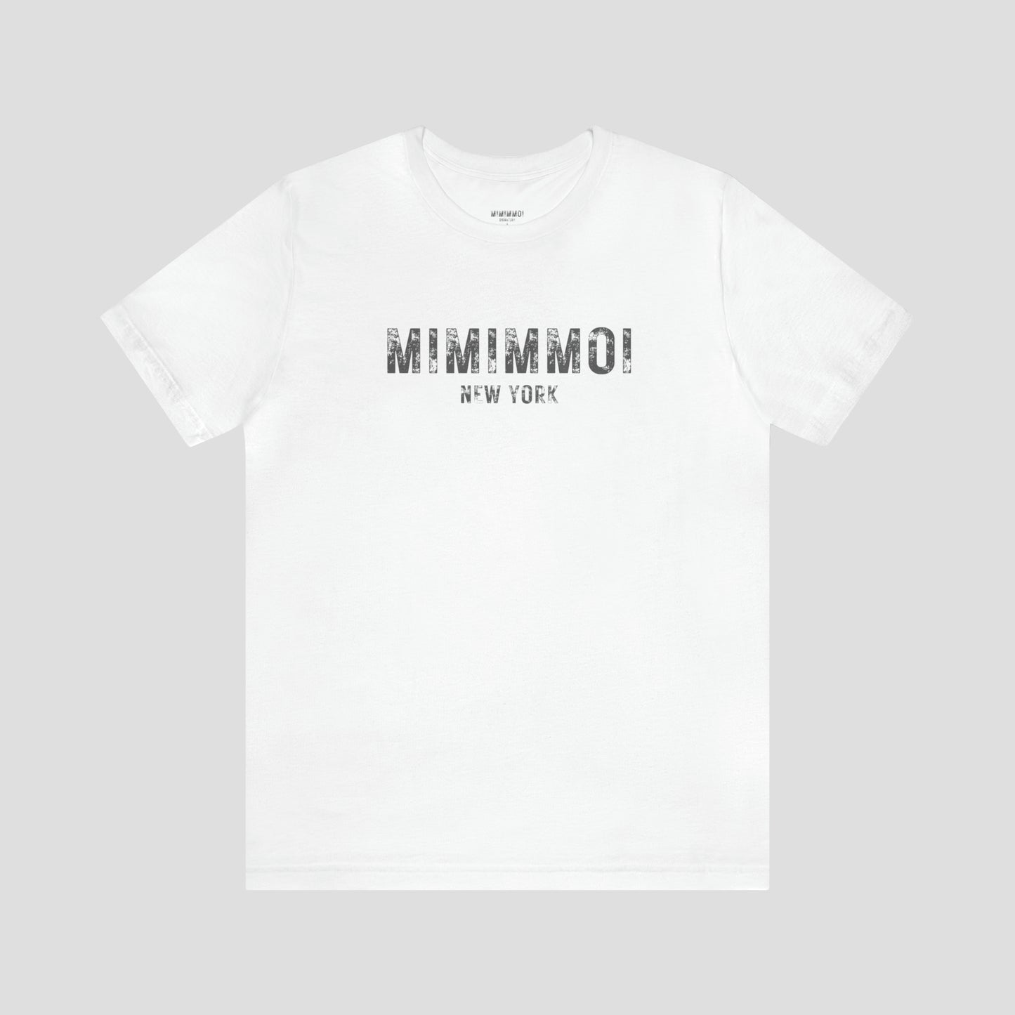 White t-shirt with the words Mimimmoi New York in distressed gray block letters across the chest, against a gray background.