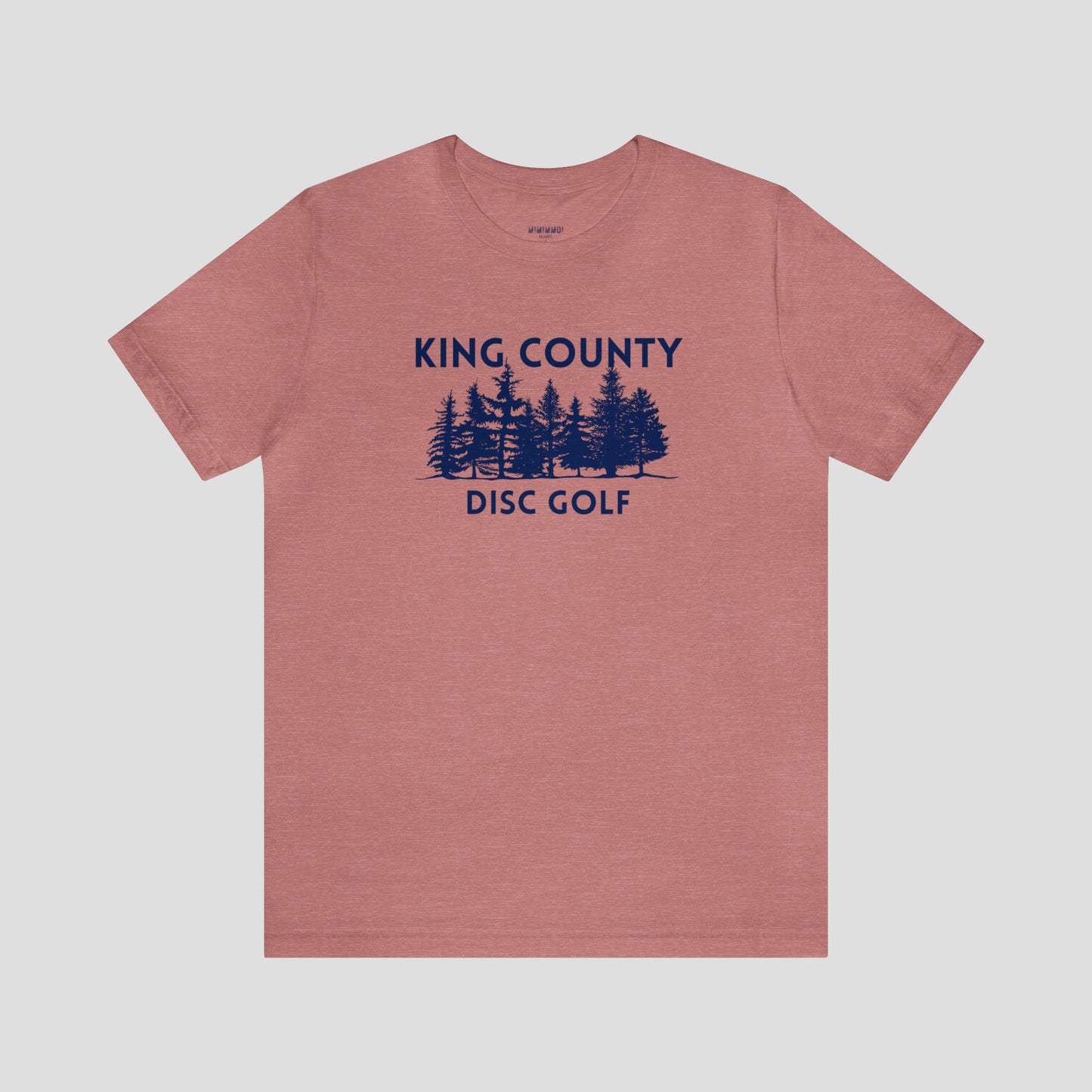 Coral t-shirt with navy letters and trees against a white background.