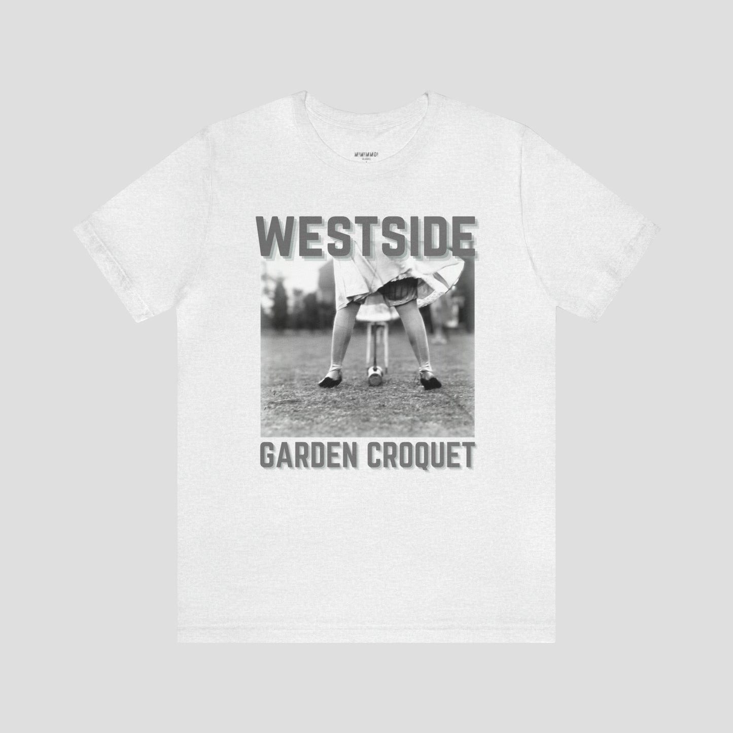 Light gray t-shirt with gray letters and a vintage photo of person bent over playing croquet against a light gray background.