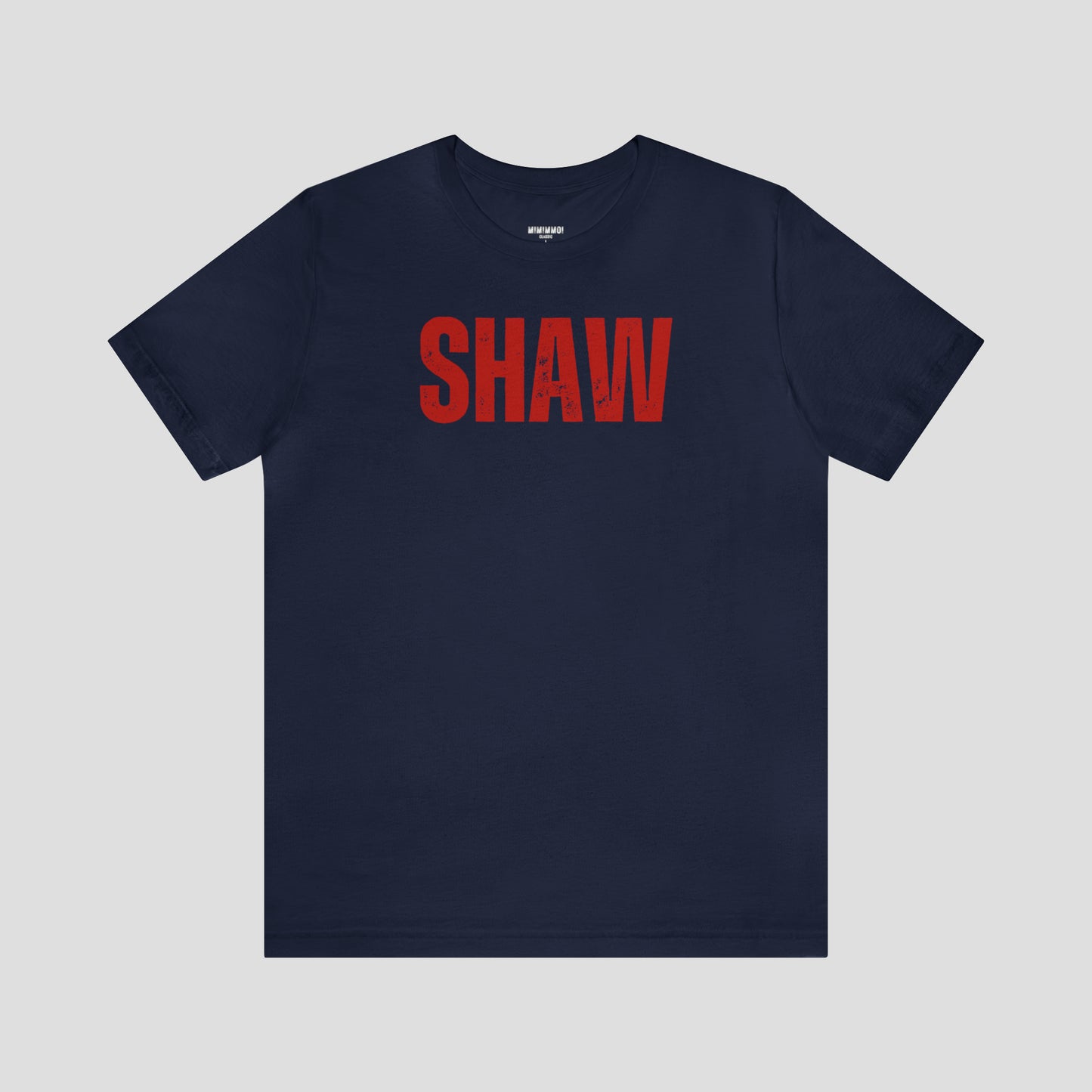 Navy blue t-shirt with the word "Shaw" in large red, grunge block letters across the chest, against a gray background.