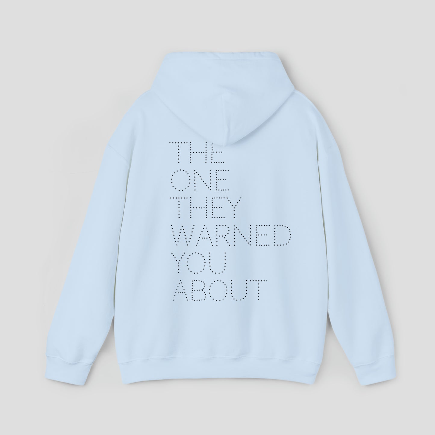 Back view of light blue hooded sweatshirt with hood down with the words "The One They Warned You About" in capitalized dotted text in center, against a gray background.