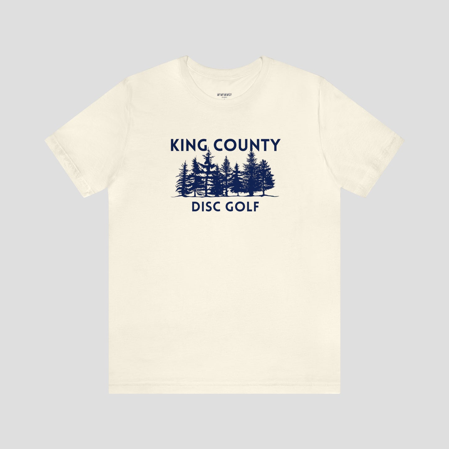 Butter colored t-shirt with navy letters and trees against a white background.