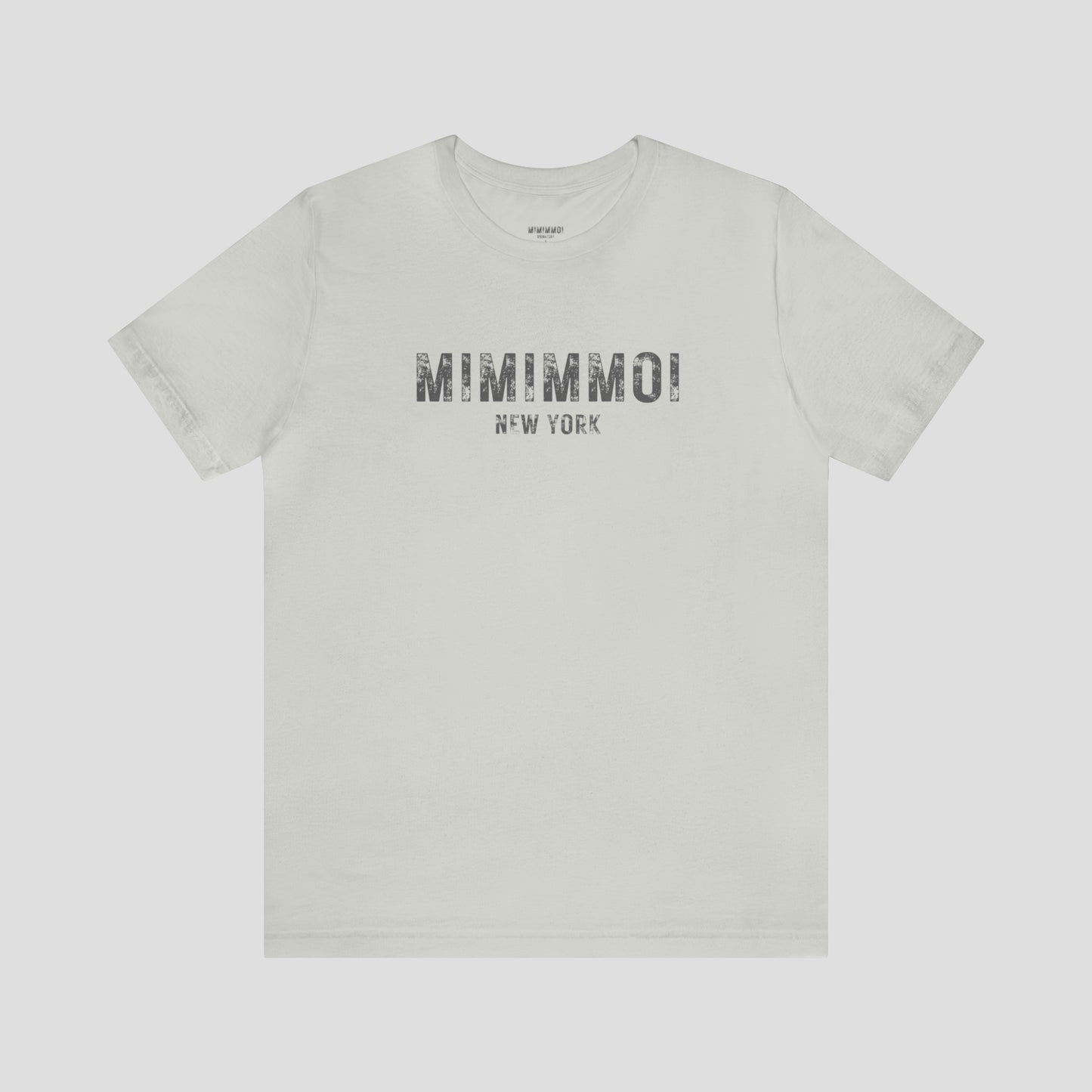 Silver-gray t-shirt with the words Mimimmoi New York in distressed gray block letters across the chest, against a gray background.