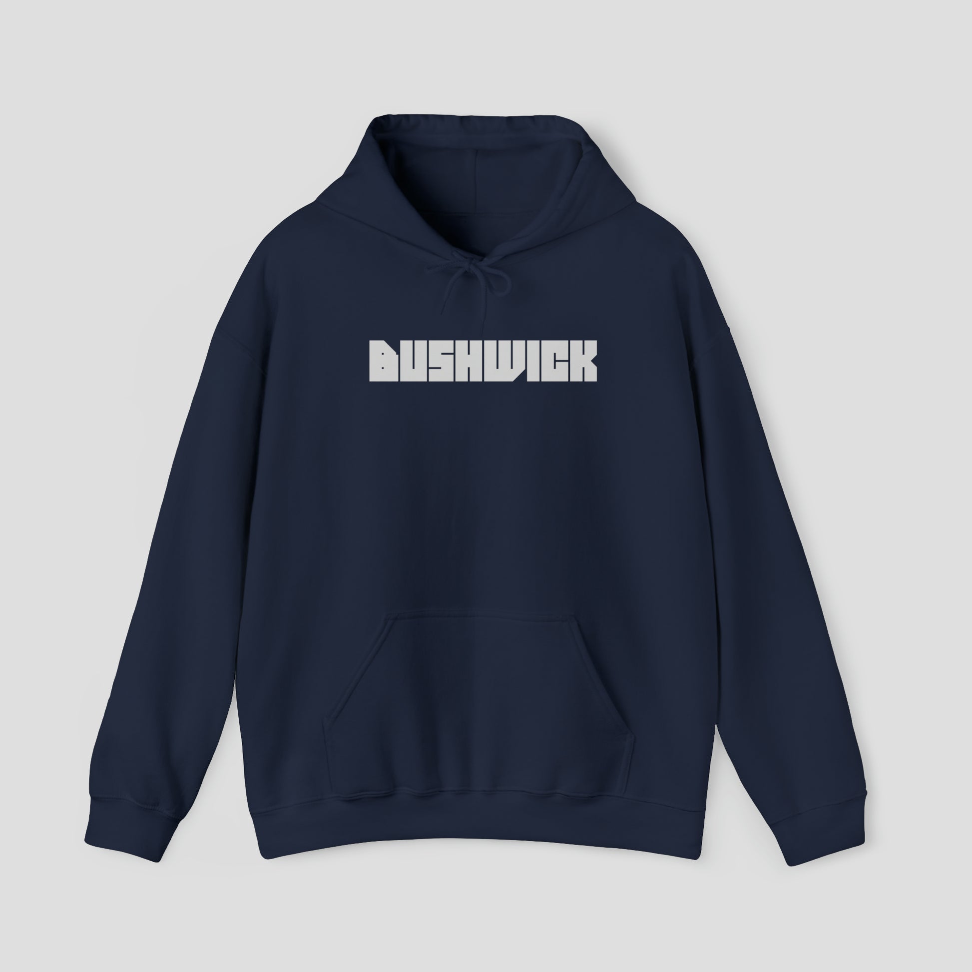 Front view of a navy blue hooded sweatshirt with hood down and the word "Bushwick" in a large white block letters in center, against a gray background.