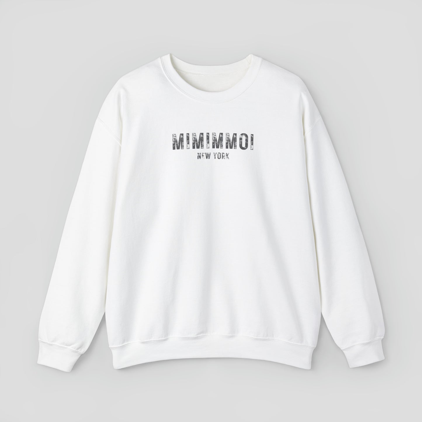 White sweatshirt with the words Mimimmoi New York in distressed gray block letters across the chest, against a gray background.