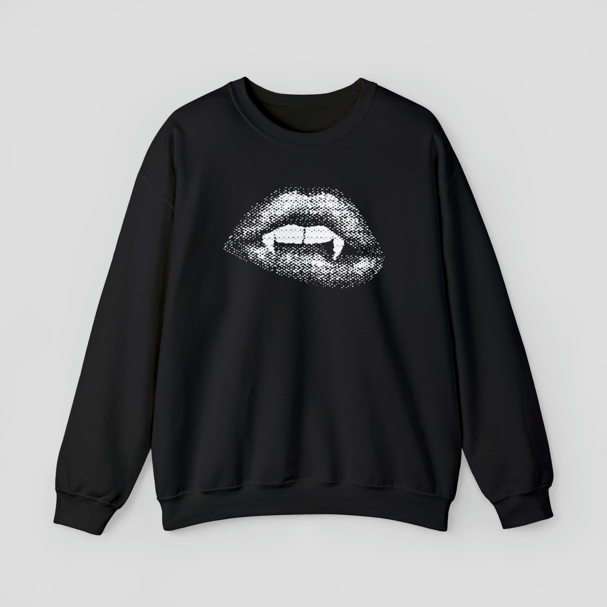 Black sweatshirt with open mouth and lips exposing two teeth and two vampire fangs against light gray background.